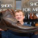 David Gummers with a giant brown boot - one of two - being auctioned by 1818 Auctioneers on Tues 6 August..jpg